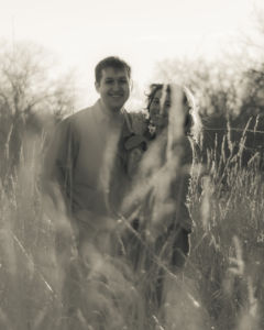 Skylar and Aaron holding each other in golden field.