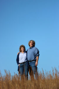 Portrait of Andy and Rose Derrickson standing in a field.