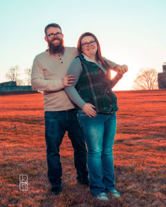 Dave and Bethany Strieff hold each other close with the sunset behind them in red hues