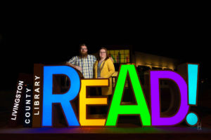 Dave and Bethany Strieff pose near the LIvingston county Missouri childrens library READ sign